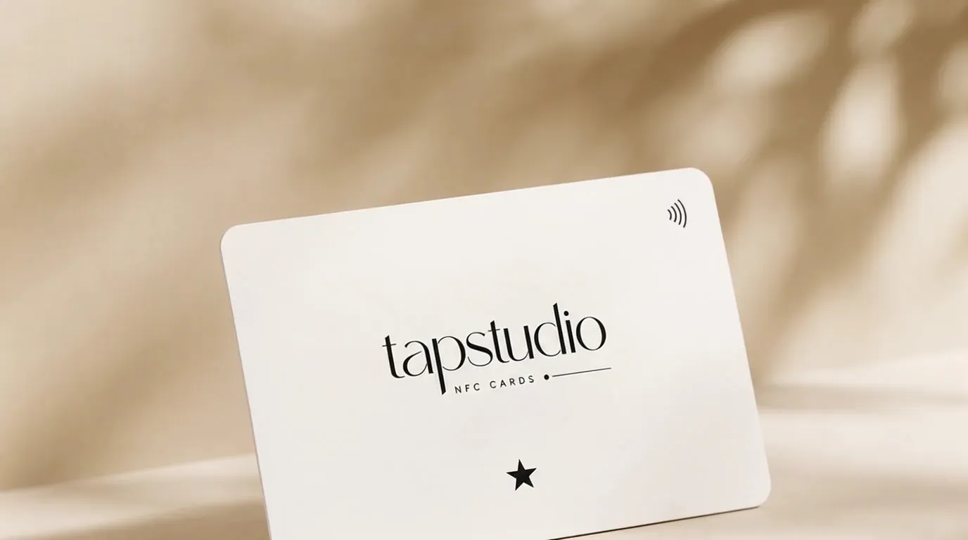 Official white TapStudio NFC card with black serif logo on a warm neutral background.